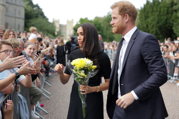 Meghan, Duchess of Sussex and Prince Harry, Duke of Sussex speak with well-wishers at Windsor Castle.