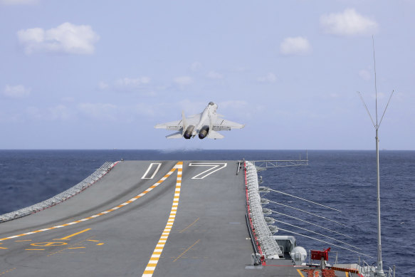 A Chinese fighter jet takes off from the Shandong aircraft carrier during a combat-readiness patrol.
