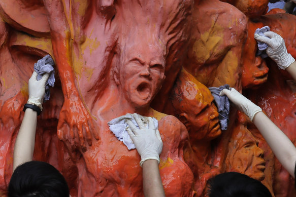 University students clean the “Pillar of Shame” statue, a memorial for those killed in the 1989 Tiananmen crackdown, at the University of Hong Kong in 2019.