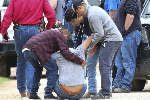 A loved one is consoled by others as he arrives at the scene of the mass shooting in San Jacinto County, Texas. 