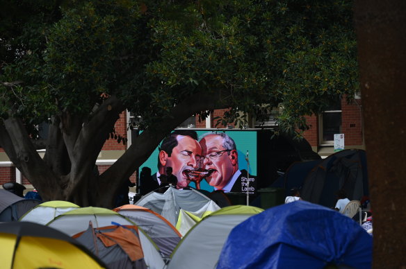 A billboard ad featuring Mark McGowan goes by ‘tent city’ in Fremantle as the camp is closed and homeless people are bussed to temporary hotel accommodation. 