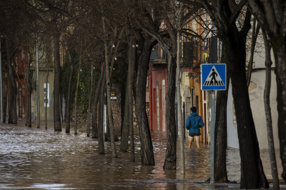 A man walks through floodwater following a storm in Girona, Spain.