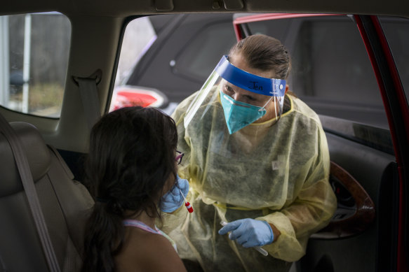 A healthcare worker administers a COVID-19 test to a child at the Austin Regional Clinic drive-thru vaccination and testing site in Austin, Texas.