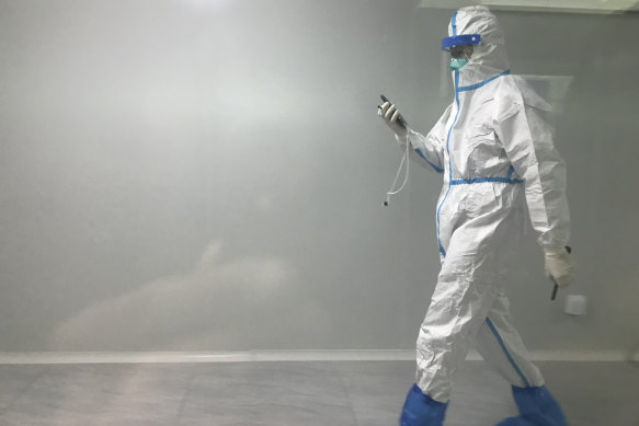 A worker in protective gear walks through a corridor at Guangzhou Baiyun Airport, south China's Guangdong province, December 25, 2022.