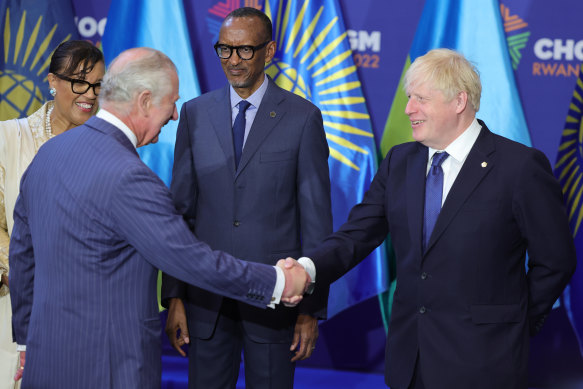 Prince Charles shakes hands with Prime Minister Boris Johnson, in front of Rwanda’s President Paul Kagame, before the CHOGM opening ceremony.