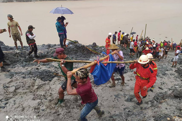 Rescuers carry a recovered body of a victim in a landslide from a jade mining area in Hpakant, Kachine state, northern Myanmar.