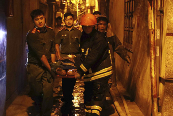 Rescue workers carry a person on stretcher out of a building on fire in Hanoi, Vietnam, on  Wednesday. 