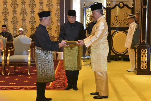 Muhyiddin Yassin, left, is sworn in by King Sultan Abdullah Sultan Ahmad Shah at the National Palace in Kuala Lumpur. 