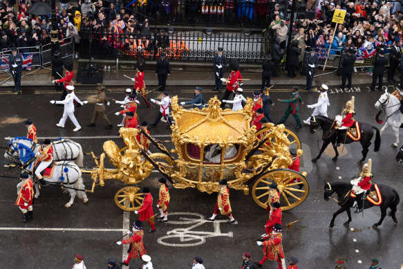 King Charles III and Queen Camilla travelling in the Gold State Coach, which was built in 1760. It has been used at every coronation since that of William IV in 1831. 