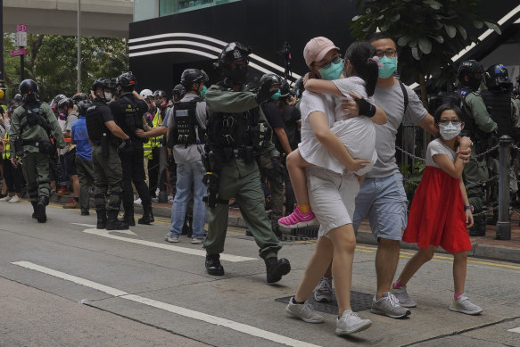 A family walks away as riot police fired tear gas during a protest against Beijing's national security legislation in Hong Kong on Sunday, May 24. 
