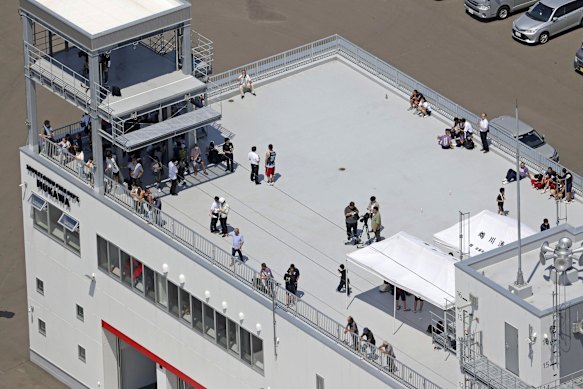 People seek safety on the roof of a fire station in northern Japan.