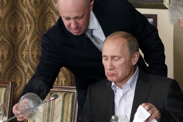 Yevgeny Prigozhin, top, serves food to then-Russian Prime Minister Vladimir Putin at Prigozhin’s restaurant outside Moscow, Russia on Nov. 11, 2011