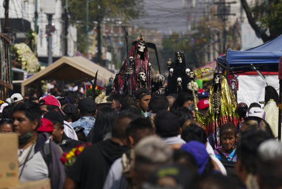 Devotees hold an ornately decorated statue of “Nuestra Señora de la Santa Muerte,” or Our Lady of Holy Death, in Mexico City’s Tepito neighborhood.