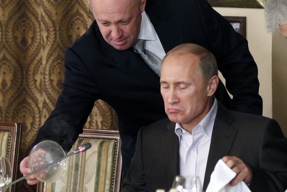 Yevgeny Prigozhin (top) serves food to then-Russian Prime Minister Vladimir Putin at Prigozhin’s restaurant outside Moscow on November 11, 2011.