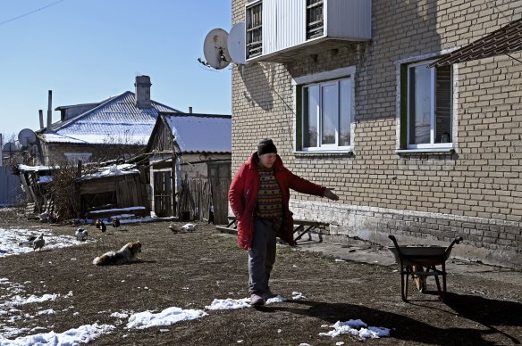Olena Miroshnychenko, cleans up broken glass after mortars landed in her backyard, shattering the windows of her home in Kamyanka. 