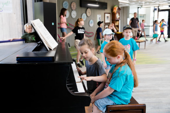 It takes a village: students play a grand piano during lunch time at Lindfield Learning Village.