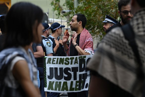 Palestinian activist and academic Fahad Ali (centre) attends a protest outside Creative Australia offices.