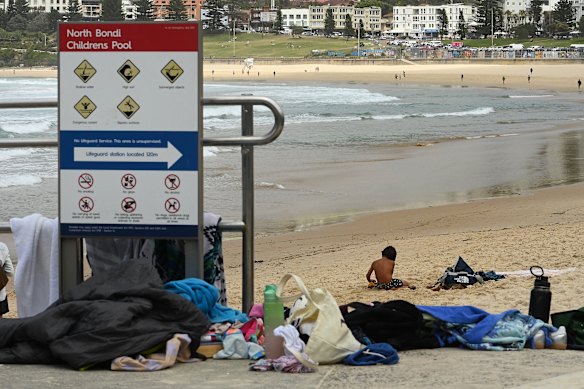 Children at the northern end of Bondi Beach near possessions abandoned by fleeing beachgoers during the shooting on Sunday.