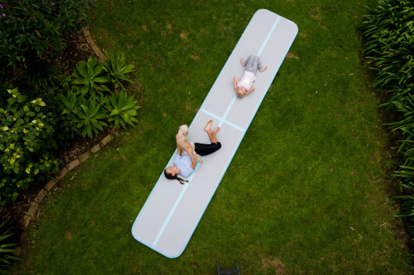 Ella and Scarlett Chappell playing on their new inflatable gymnastics mat.
