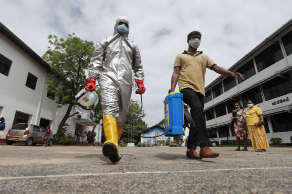 Members of Sri Lanka's St John's Ambulance disinfect a school in Colombo.