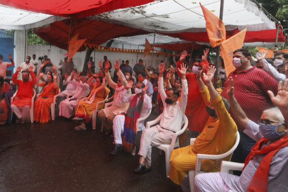 Hindus shout religious slogans as they watch a live telecast on a giant screen the groundbreaking ceremony.
