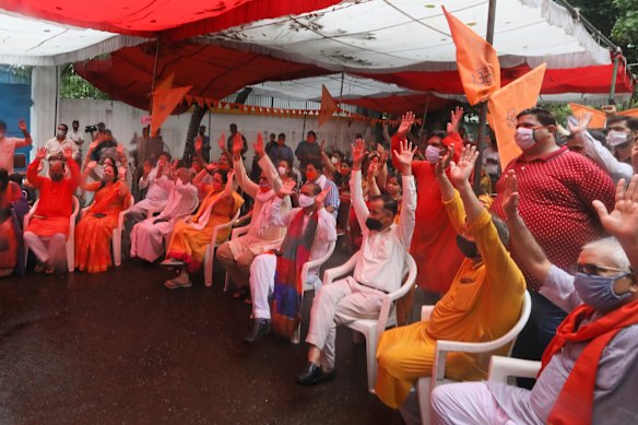 Hindus shout religious slogans as they watch a live telecast on a giant screen the groundbreaking ceremony.