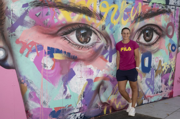 Ashleigh Barty in front of the mural of her at Melbourne Park.
