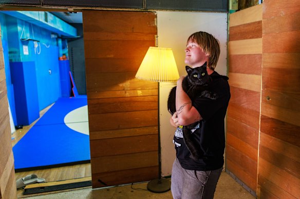 Franki with their cat inside Mothership, where there is also a wrestling room tucked in the back.