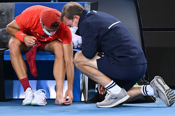 Lorenzo Musetti receives treatment. 