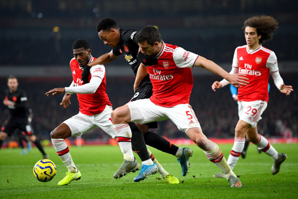 Manchester United's Anthony Martial (centre) is challenged by Arsenal duo Ainsley Maitland-Niles (left) and goalscorer Sokratis Papastathopoulos.