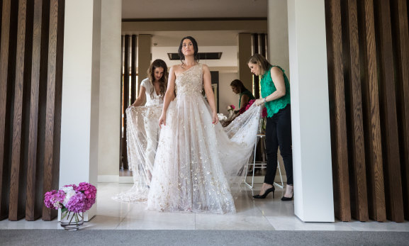 Aphrodite Spiropoulos (centre) tries on a rental gown by Klovia Couture’s Sylvia Ktori (left) and Kony Diaman.