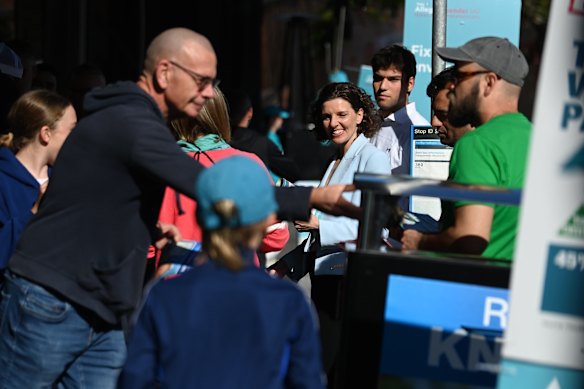 Independent candidate for Wentworth Allegra Spender (centre) talks with people queuing to vote at Saint George’s Church voting centre in Paddington, NSW.