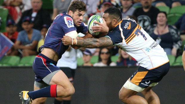 Tom English of the Rebels is tackled by  Lolo Fakaosilea of the Brumbies.
