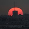 The sun sets over damaged buildings in the Gaza Strip last month.