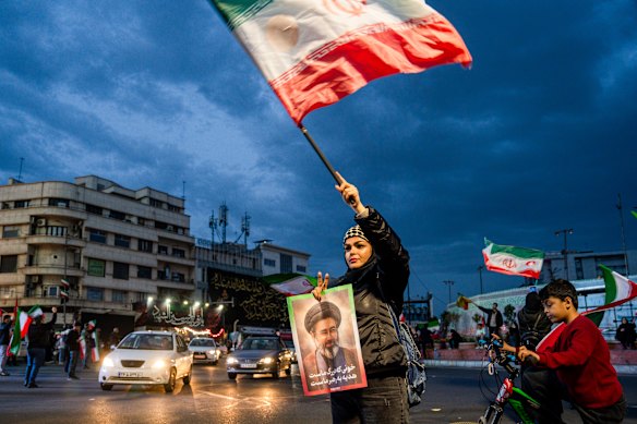 People wave flags in support of the Iranian government in central Tehran in a rally held last weekend.