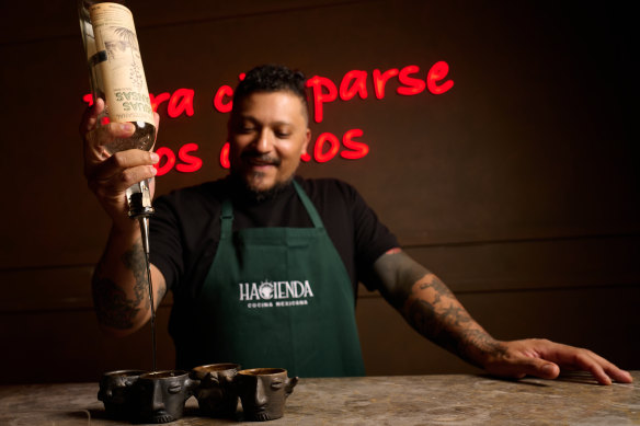 Ramon Tovar pours mezcal into hand-made shot cups Haceinda imported from Mexico.