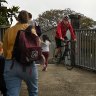 Cyclists pass students and parents approaching the entrance to Fort Street Public School in Millers Point.