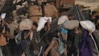 Palestinians carry sacks of flour unloaded from a humanitarian aid convoy that reached Gaza City from the northern Gaza Strip.
