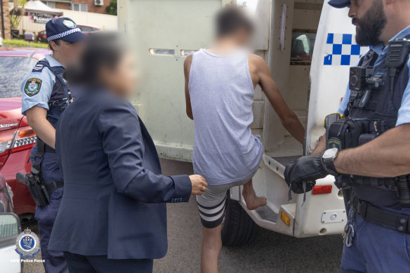 A teenager is arrested in a counter-terrorism raid in Sydney last month.