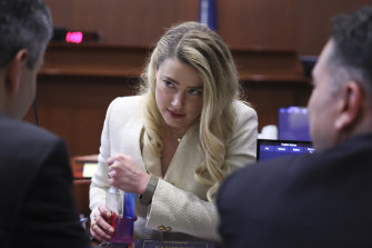 Amber Heard talks to her lawyer.