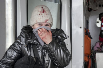 A woman reacts as paramedics perform CPR on a girl who was injured during shelling in Mariupol.