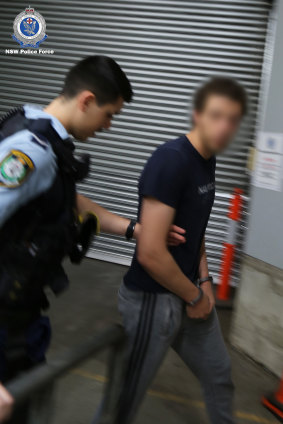 The suspect arrives at Bankstown police station.