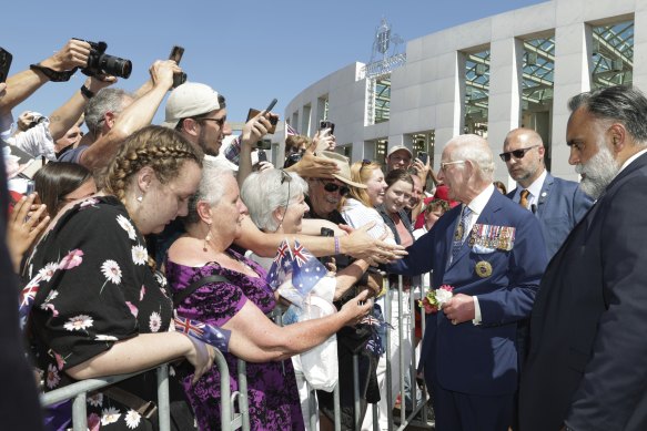 The King greets the public has he leaves Parliament House. 