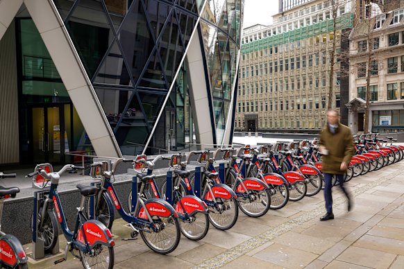 Uma estação de aluguel de bicicletas na calçada abaixo do 30 St Marys Axe de Londres, também conhecido como Gherkin. 