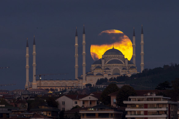 İstanbul, Türkiye'de Çamlıca Camii'nin arkasında dolunay yükseliyor.  Şehir, 2026 iklim müzakerelerine ev sahipliği yapmak istiyor.