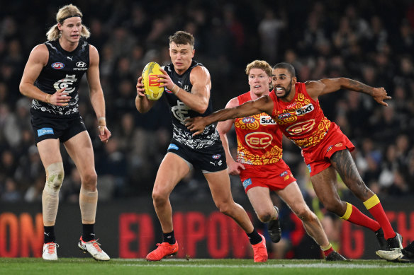 Patrick Cripps of the Blues breaks away from Touk Miller of the Suns.