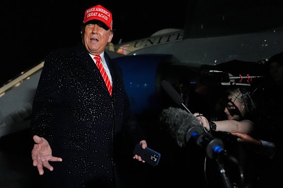President Donald Trump speaks to reporters in the rain after arriving at Joint Base Andrews in Maryland on Friday.
