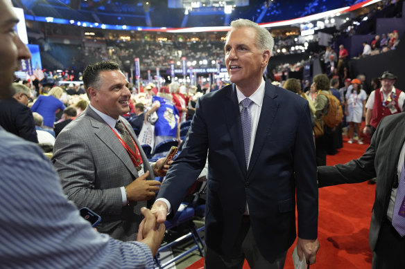 Former Speaker of the House Kevin McCarthy shakes hands with a delegate on the floor of the Republican National Convention.