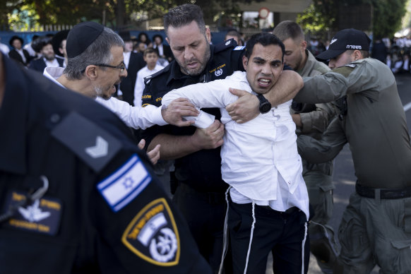Ultra-Orthodox Jewish men clash with police officers during a protest against drafting into the Israeli army in Bnei Brak, Israel.