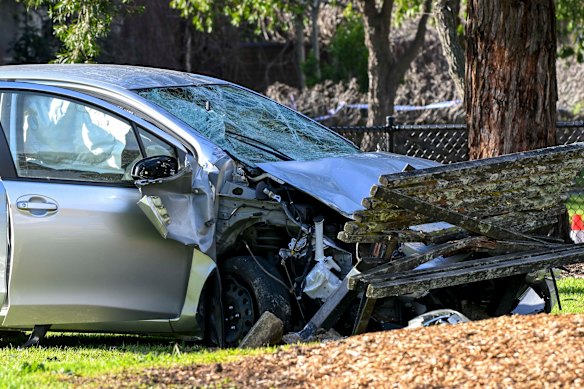 Damage can be seen on the car and a park bench. 